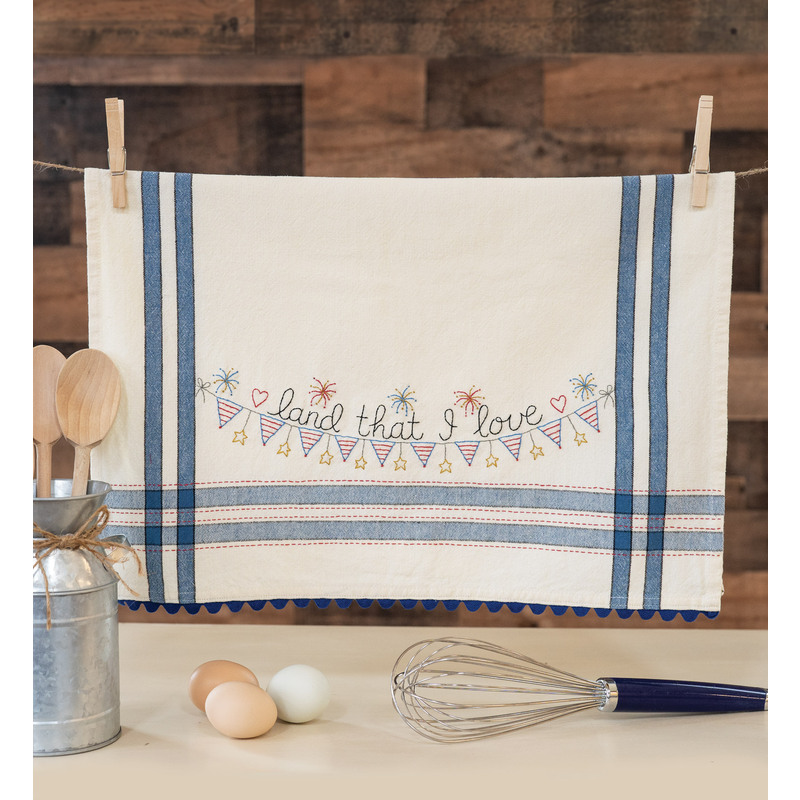 A vintage style dish towel with hand embroidered bunting, fireworks, and the words 